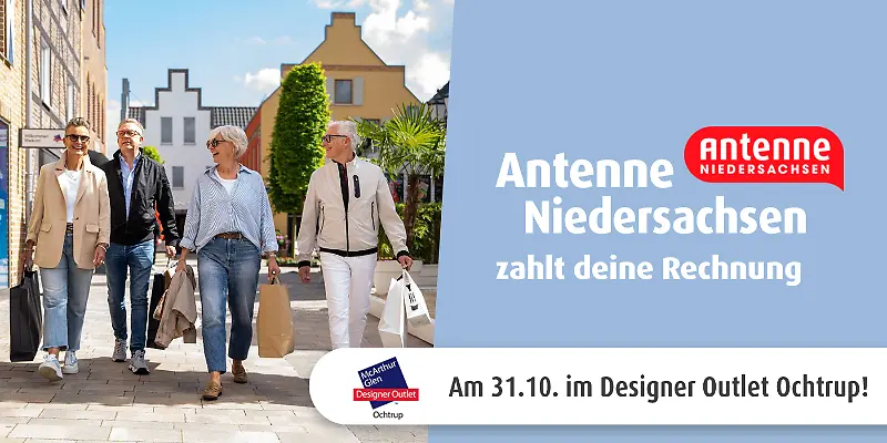 Vier Personen gehen mit Einkaufstaschen durch das Designer Outlet Ochtrup.