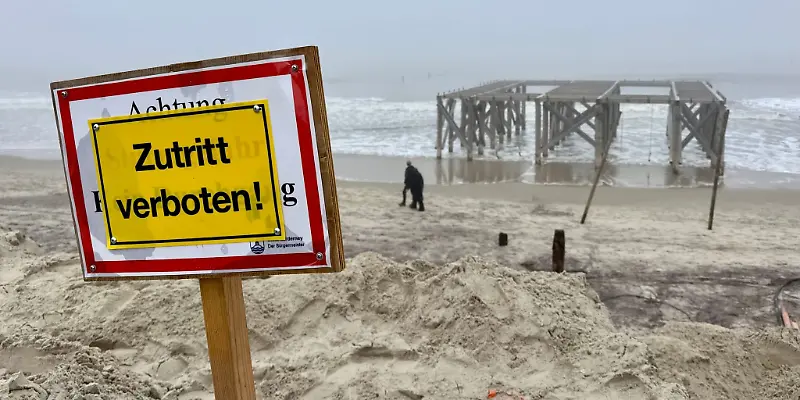 Spaziergänger auf Norderney laufen am Strandabschnitt «Weisse Düne» hinter einem «Zutritt verboten» Schild